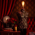 Black and Copper Feather Mannequin Floor Lamp with Black Wooden Stand - Decorative lamp on a mannequin torso with a patterned wall and red curtain in the background.