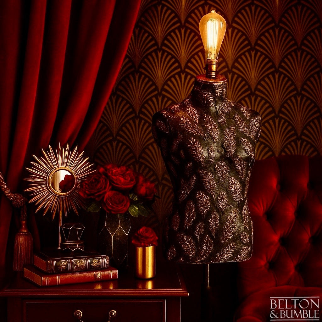Black and Copper Feather Mannequin Floor Lamp with Black Wooden Stand - Decorative lamp on a mannequin torso with a patterned wall and red curtain in the background.