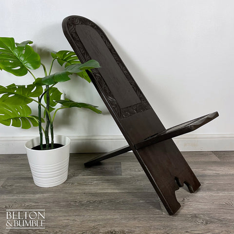 Carved African Palaver Chair – Styled product shot with complementary decor to suggest scale