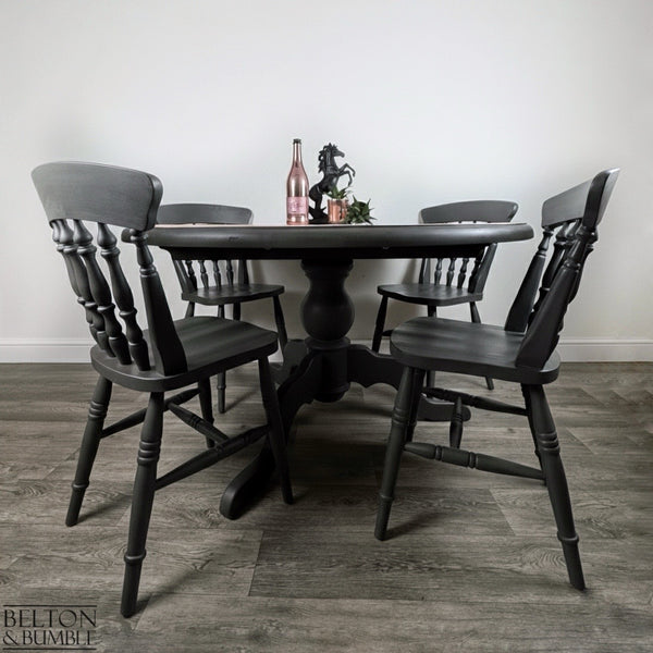 Circular pedestal dining table with four dark grey farmhouse chairs hand-painted in chalk paint.