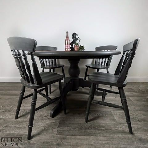 Circular pedestal dining table with four dark grey farmhouse chairs hand-painted in chalk paint.