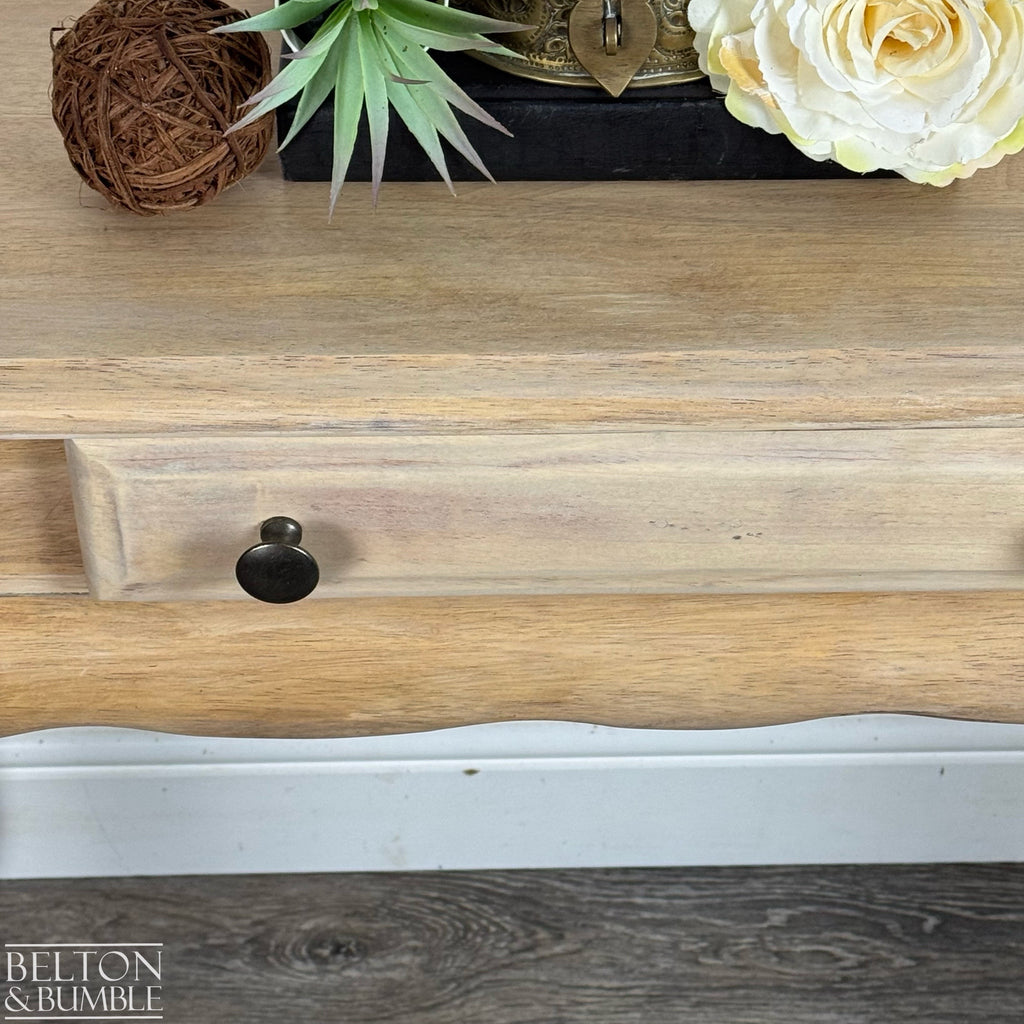 Close-up of the console table drawer featuring round brass-style knobs and natural wood finish.