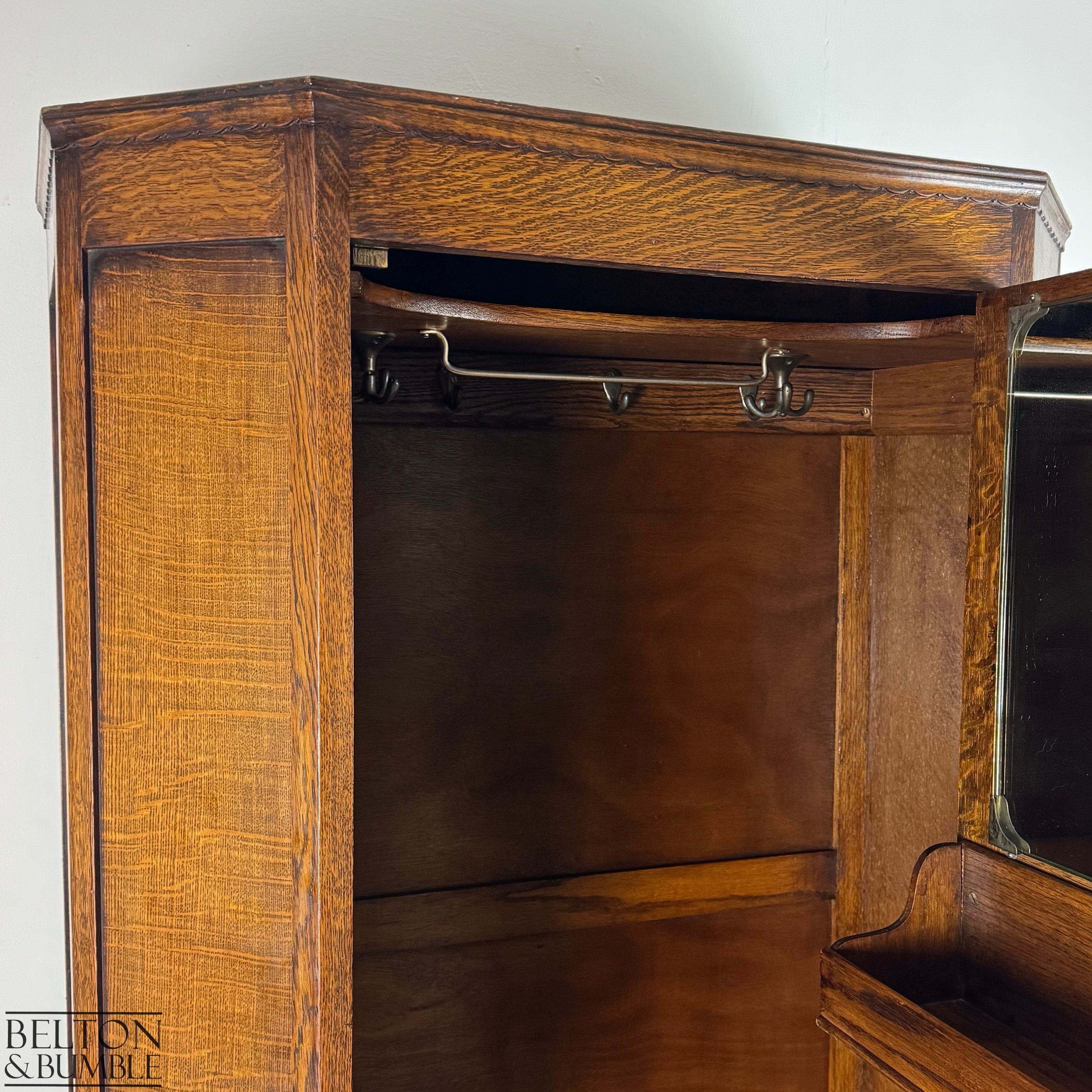 Interior view of the wardrobe showing fixed hooks, spinning hooks, and the upper hanging rail.
