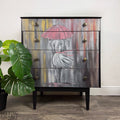 Jet-black chest of drawers with hand-painted figure and pink umbrella design