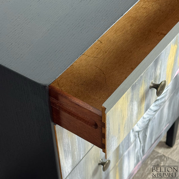 Open drawer with dovetail joints and natural wood interior beneath the painted front.