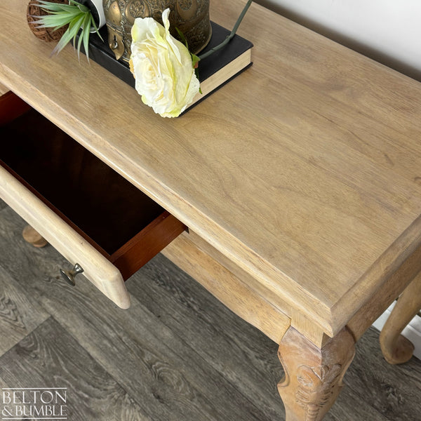 Top-down view of console table showing open drawer, carved leg details, and natural grain wood texture.
