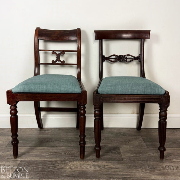 Two antique mahogany dining chairs side by side against a light wall, each with teal upholstered seats; the left chair has a simple scroll-carved back splat while the right chair features an ornate floral carved splat, both with turned front legs and rich dark wood grain.