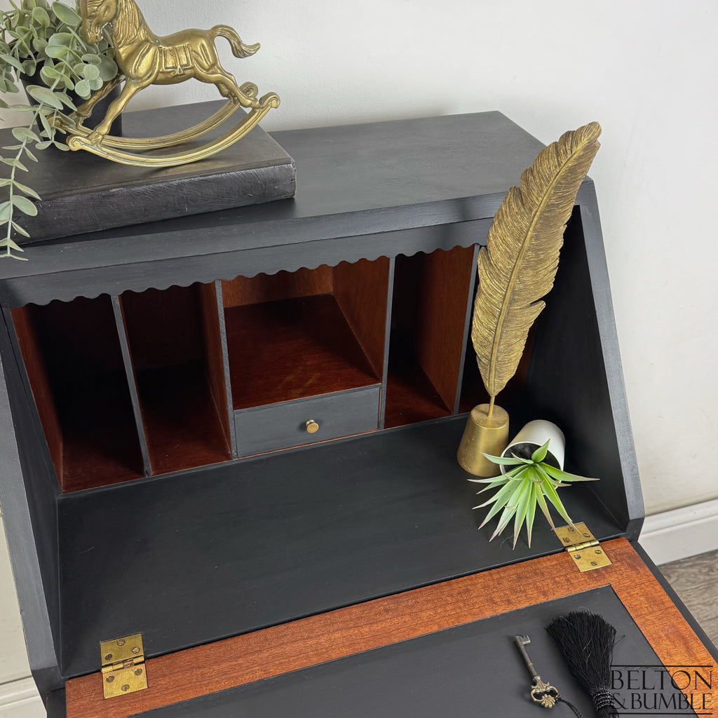 Detail of vintage writing desk interior with black painted finish and small central drawer
