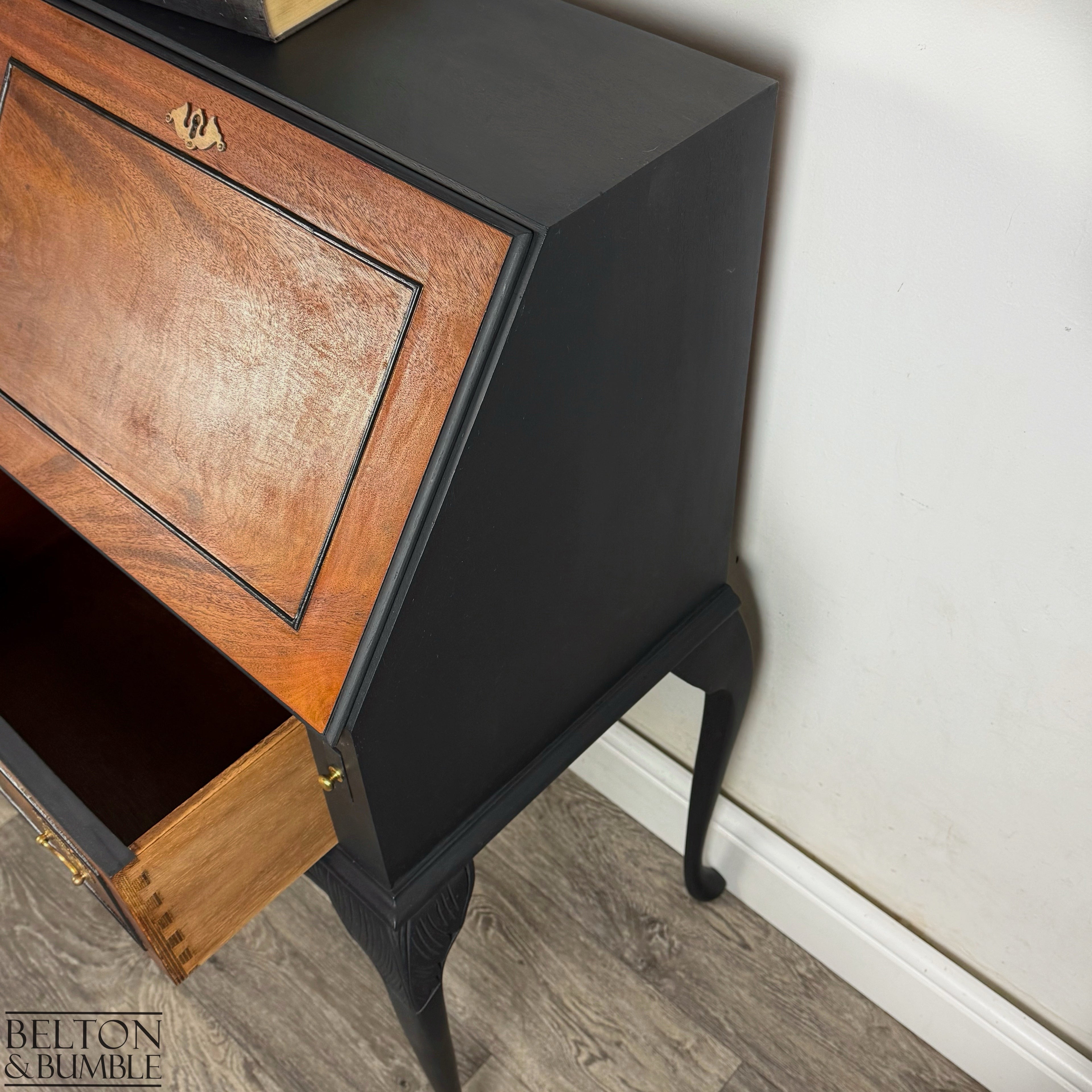 Side view of black-painted Queen Anne bureau with burr walnut front and elegant curved legs