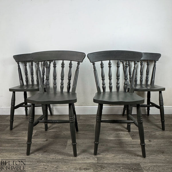 Four spindle-back farmhouse chairs hand-painted in rich dark grey chalk paint.