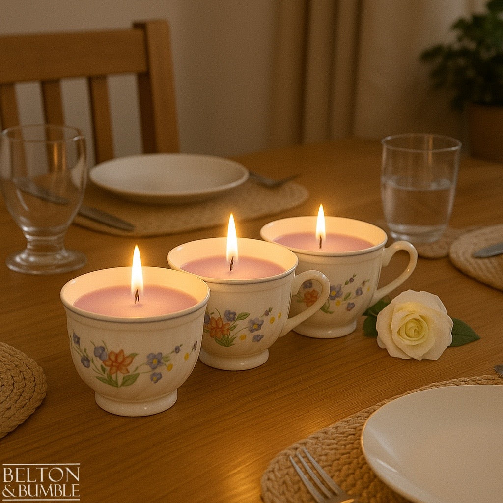 Soy Wax Vintage Teacup Candle with Orchid Scent  - Trio of orchid-scented soy wax candles glowing warmly in floral vintage teacups on a dining table setting.