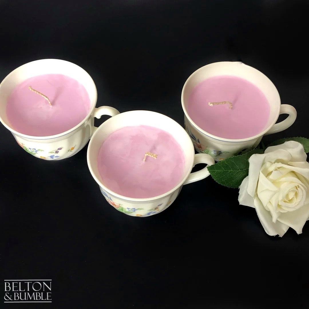 Soy Wax Vintage Teacup Candle with Orchid Scent  - Overhead view of three pink orchid soy wax teacup candles with braided wicks and white rose accent.