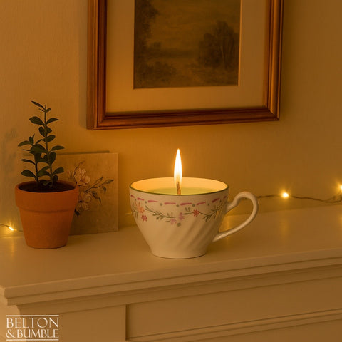 Soy Wax Vintage Teacup Candles with Green Apple Scent - Lit soy wax candle with green apple scent in a delicate floral vintage teacup, glowing softly on a mantel with potted plants.